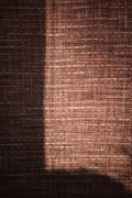 Vliesová tapeta s výrazným textilním vzorem, barva hnědá, jemná matná struktura. Kolekce Desert Lodge od německého výrobce tapet A.S.Création